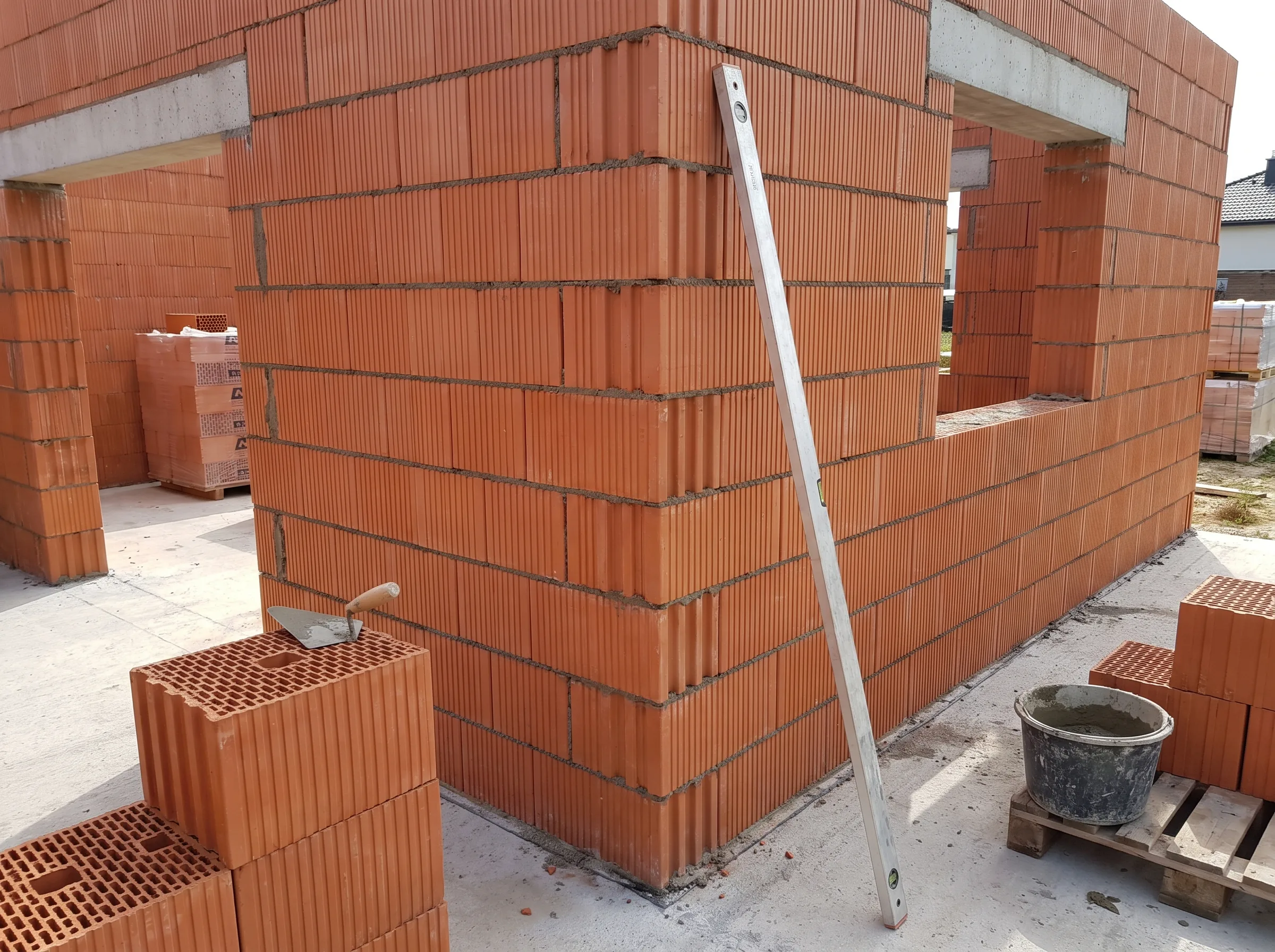 Murowanie ścian z cegły ceramicznej podczas budowy stanu surowego otwartego